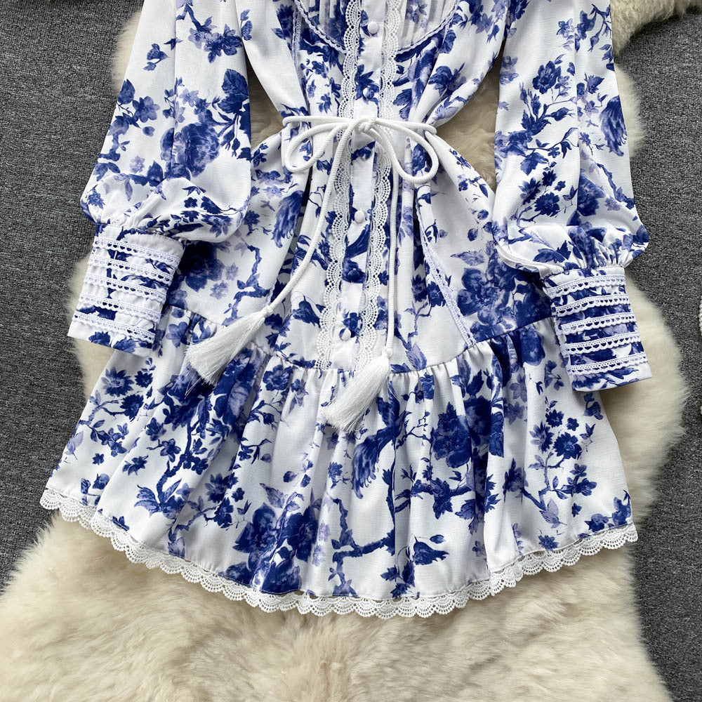 Vestido elegante con cuello alto, mangas abullonadas, botonadura sencilla y estampado con flecos en la cintura